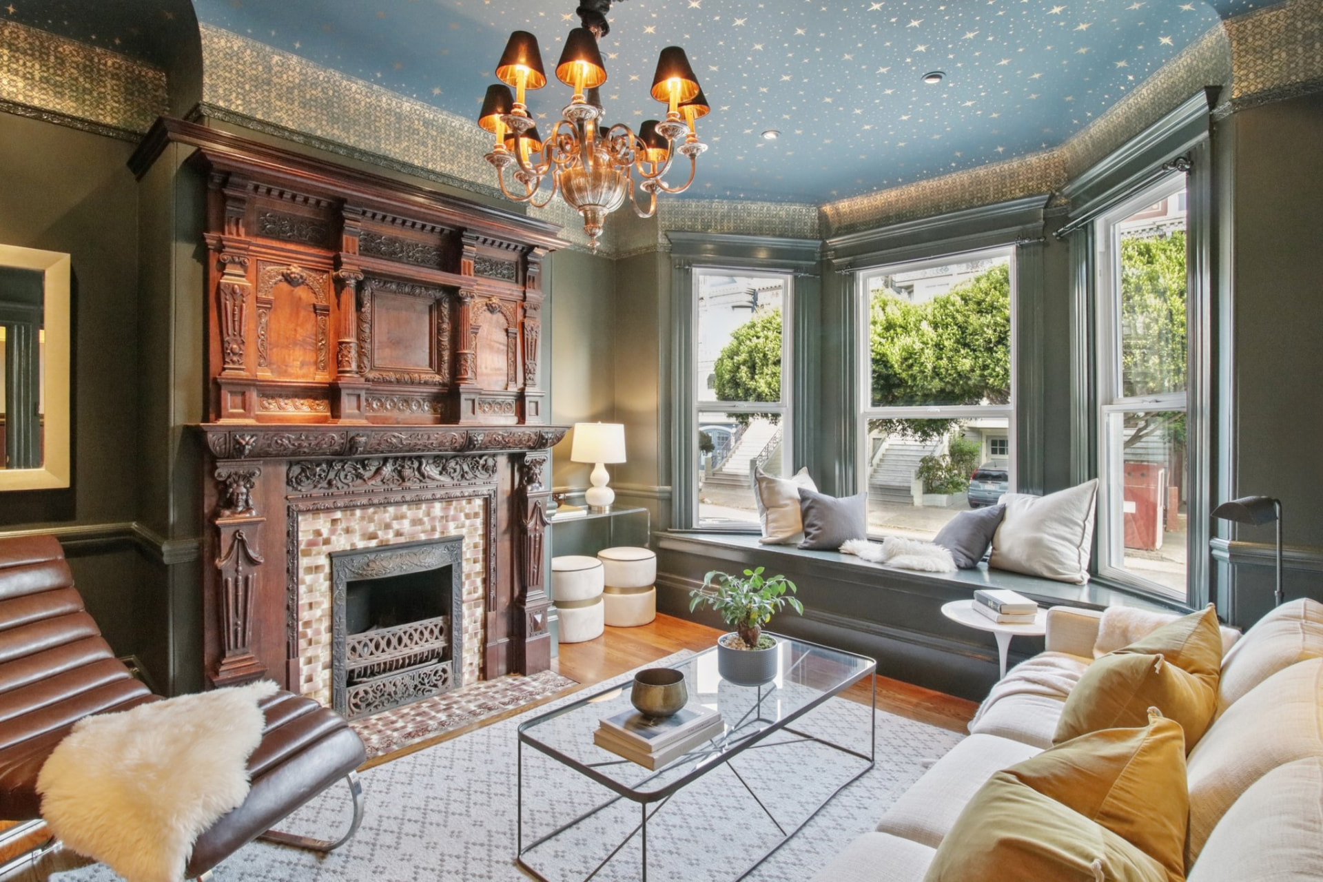 Ornate Victorian living room with carved fireplace and bay windows