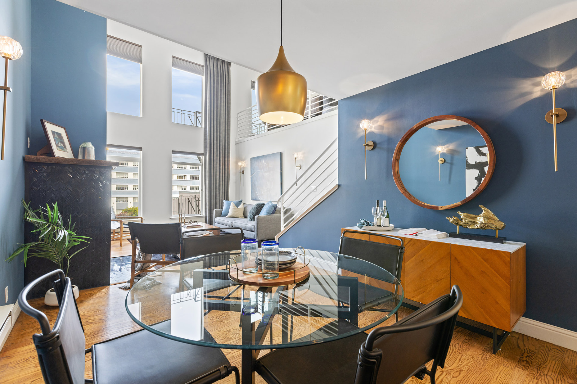 Loft dining area with brass pendant light and round mirror